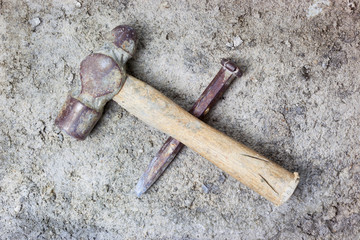 Grungy hammer and chisel on rough concrete surface