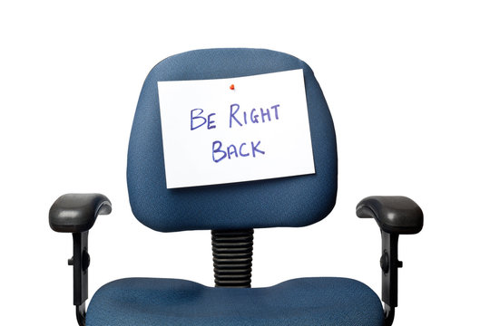 Office chair with a BE RIGHT BACK sign isolated on white