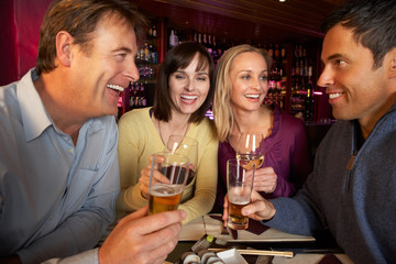 Group Of Friends Enjoying Sushi In Restaurant