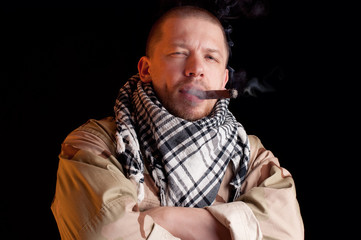 Soldier puffing some good cigar smoke, dark background