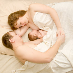 Obraz na płótnie Canvas Nice family sleeping together in a white bed