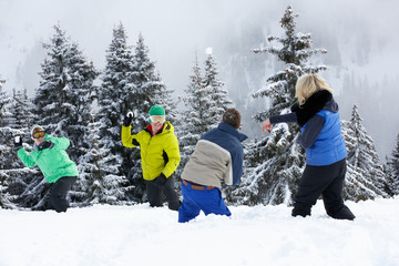 Group Of Young Friends Having Snowball Fight On Ski Holiday In M - obrazy, fototapety, plakaty