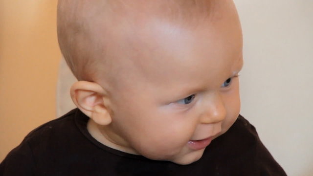 6 months boy smiling exited, looks interested