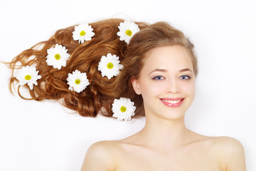Obraz na płótnie Canvas Beautiful girl with flowers in hair on a light background