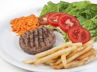Plato con hamburguesa patatas fritas y vegetales