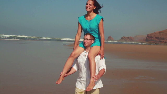 Happy couple having fun on the beach slow motion steadicam