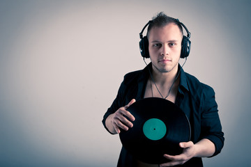 Young man working as dj with ear-phones and disc.