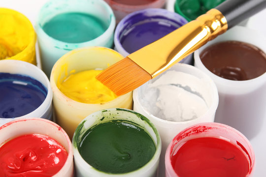 bright gouache colors in cans and paintbrush