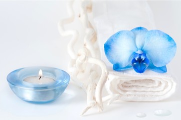 Candela con asciugamano bianco con orchidea blu