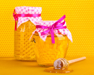 Jars of honey and wooden drizzler