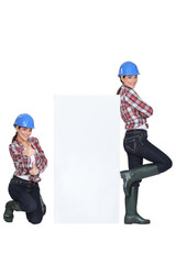 girls wearing blue hard hat striking a pose