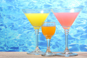 exotic cocktails on table on blue sea background