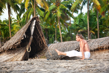 Yoga angusthasana pose on the beach