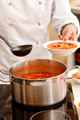chef cooking solyanka in kitchen