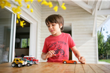 Young boy playing with his toy cars