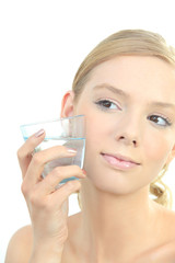 Blond woman holding glass of water to face