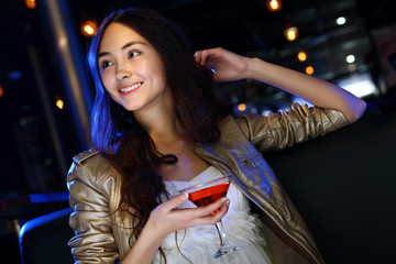 Attractive woman in night club with a drink