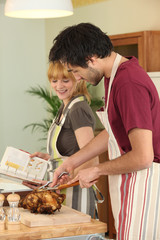 Couple preparing a meal together with the help of a cookbook