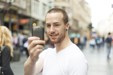 Men on street photographing with mobile phone