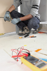 Electrician kneeling by voltmeter
