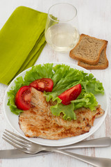 fried turkey with salad on the white plate