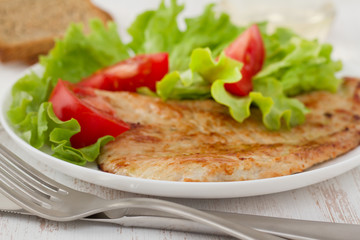fried turkey with salad on the white plate