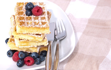 Heap of waffles with fresh fruits