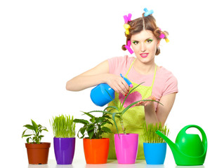 beautiful happy young housewife sprays plants