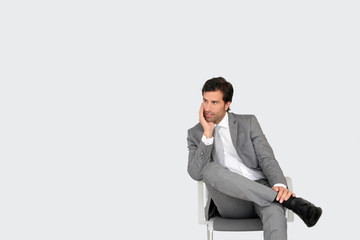 Businessman sitting on chair on grey background