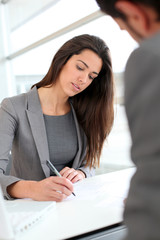 Businesswoman writing on document after meeting