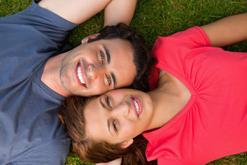 Two friends looking upwards while lying head to shoulder