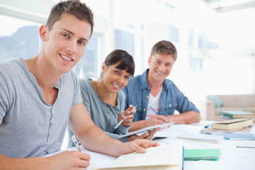 Fototapeta premium Side view of a group of young adults working together as they al