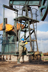 Naklejka premium worker in the oil industry on oil pump