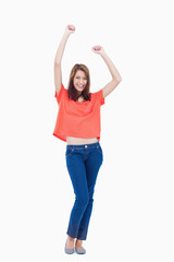 Obraz premium Laughing teenage wearing casual clothes while raising her arms