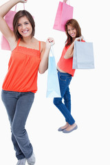 Obraz premium Smiling teenage girl followed by a friend and both are holding p