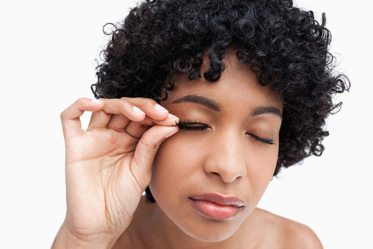 Young brunette placing false eyelashes
