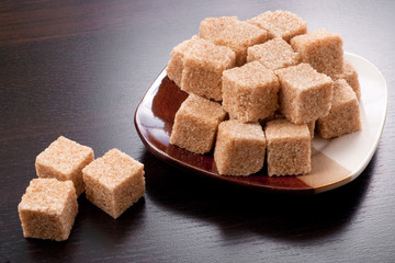 Small plate of brown sugar on black table