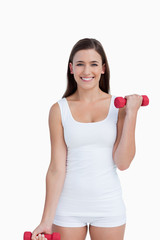 Attractive brunette holding red dumbbells