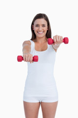 Fototapeta na wymiar Red weights being held by a young brunette