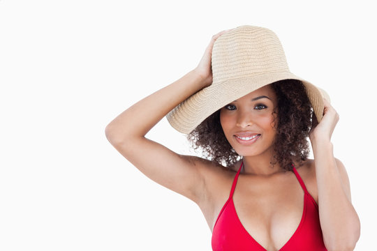 Smiling woman holding her straw hat