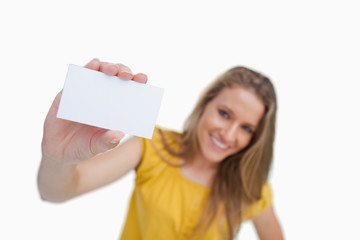 Close-up of a blond woman showing a white card