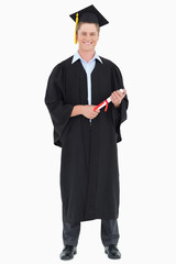 A male graduate with his degree in hand