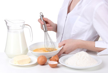 Female hands mixing eggs in bowl isolated on white