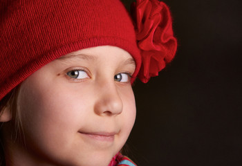 Portrait of a smiling girl, blonde in a red hat