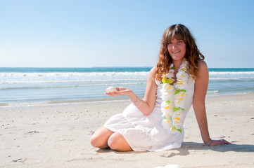 Fototapeta na wymiar Kobieta na plaży z powłoki w ręku