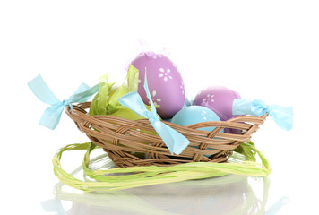 Colorful easter eggs in basket isolated on white