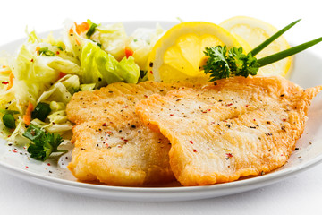 Fish dish - fried fish fillets and vegetable salad