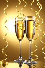 Foto op Aluminium glasses of champagne and streamer on yellow background © Africa Studio
