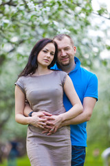 Fototapeta premium Young Couple in love in the spring blossoming apple orchard