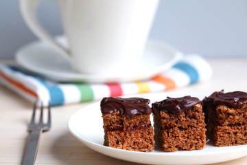 Chocolate cake squares with jam and a tea cup at the teatime